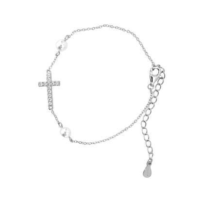 Silver bracelet with a cross charm, pearl, and teardrop pendant on a white background